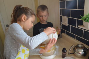 Cooking with Children- Two kids dump eggs