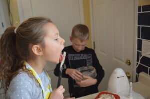 Cooking with Children- Two kids lick the batter