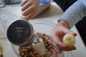 Cooking with Children- Two kids measure walnuts and bananas