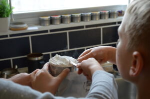 Cooking with Children- Two kids measure flour