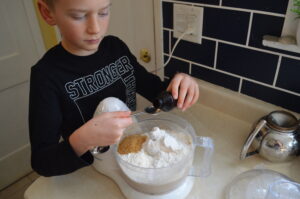 Cooking with Children- boy measures vanilla