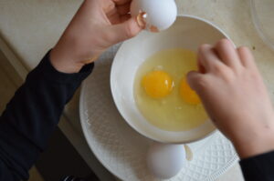 Cooking with Children- Two kids crack eggs